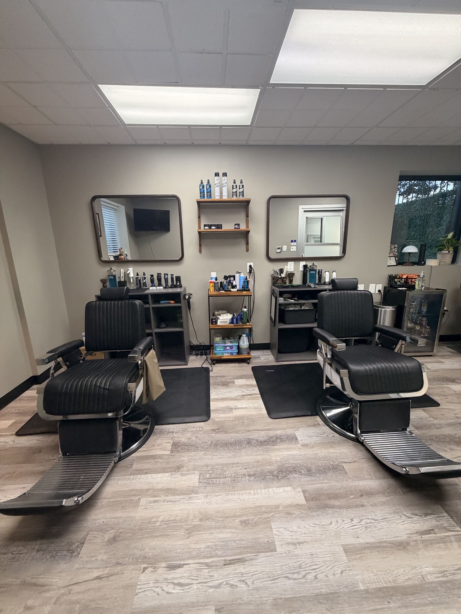 Two leather barber chairs facing mirrors inside Refined Barbers, The Heights, Houston